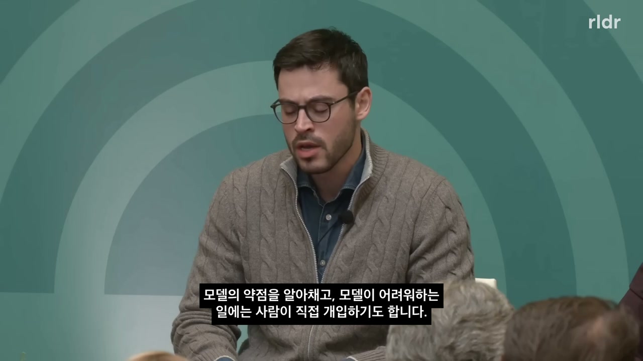 Tamay Besiroglu가 모델의 약점을 찾고 어려운 일에 사람이 개입한다고 설명하는 장면